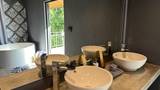 Two white vessel sinks on a stone vanity with chrome taps and a mirror.