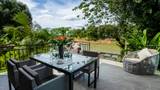 Glass-top dining table on a tiled terrace overlooking the Namkhan river and green jungle.
