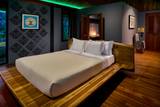 King suite bedroom with platform bed and traditional Lao artwork at The Namkhan, a boutique riverside resort in Luang Prabang, Laos