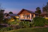 Namkhan riverside villa with illuminated wooden architecture and private terrace overlooking tropical gardens during twilight hour
