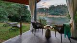 A terrace with rope chairs and side table overlooking the Namkhan River at dusk.