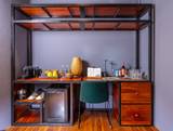 Well-appointed minibar station at The Namkhan resort in Luang Prabang, featuring Nespresso machine, premium spirits, and local crafts in warm teak.