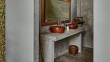 Double wooden vessel sinks on a concrete vanity with a teak-framed mirror.