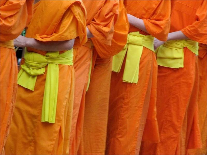 Buddhist monks in traditional orange robes during daily alms ceremony in Luang Prabang, near The Namkhan resort in Laos.