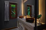 Double wooden basin vanity with brass fixtures and jungle views through window at The Namkhan boutique hotel in Luang Prabang, Laos