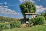 Modern riverside villa with floor-to-ceiling windows overlooking lush greenery at The Namkhan resort in Luang Prabang, Laos