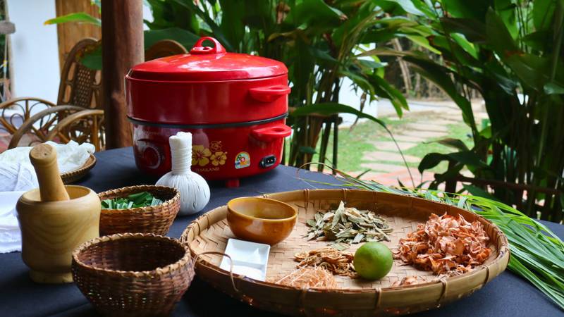 Traditional Lao herbal therapy ingredients with mortar, pestle, and rice cooker at The Namkhan wellness spa in Luang Prabang, Laos