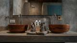 Pair of wooden vessel sinks on concrete vanity with folded towels and amenity bottles.