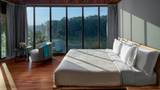 A king bedroom in a riverside villa with floor-to-ceiling windows overlooking the Namkhan River.
