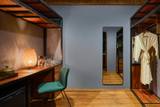 Elegant dressing area with minibar and wardrobe at The Namkhan luxury resort in Luang Prabang, featuring warm wood tones and contemporary design.