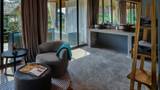 A grey upholstered armchair beside large glass doors in a suite interior.