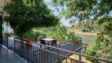A furnished balcony terrace overlooks the Namkhan River surrounded by dense green trees.