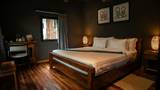 A king bedroom with dark walls, teak wood floors, white bedding, and local artwork above the headboard.