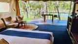 Spacious tent suite interior at The Namkhan overlooking the Nam Khan River in Luang Prabang, featuring king bed and private terrace with garden access